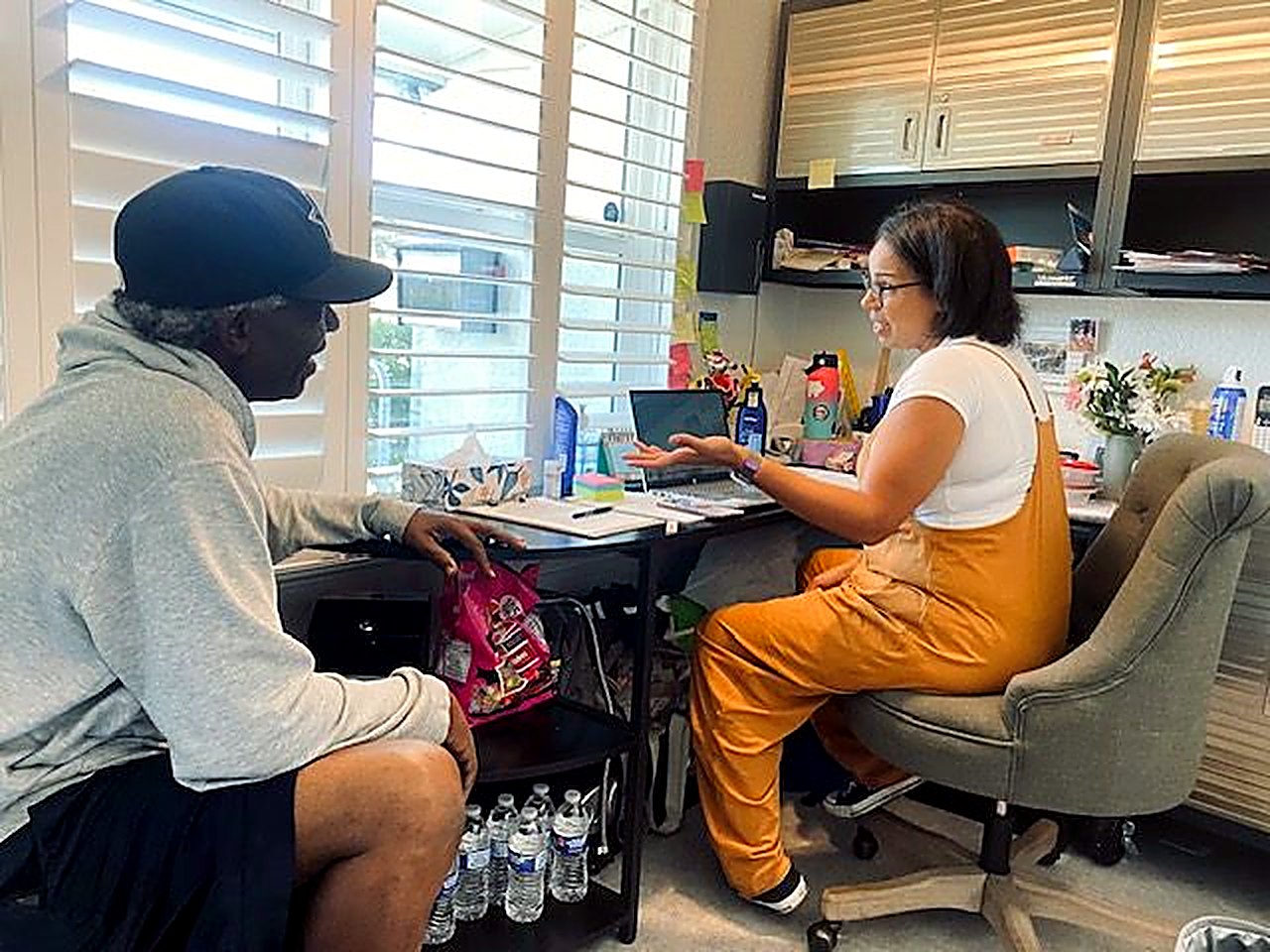 A Coalition team member sitting down with a man to talk through his application